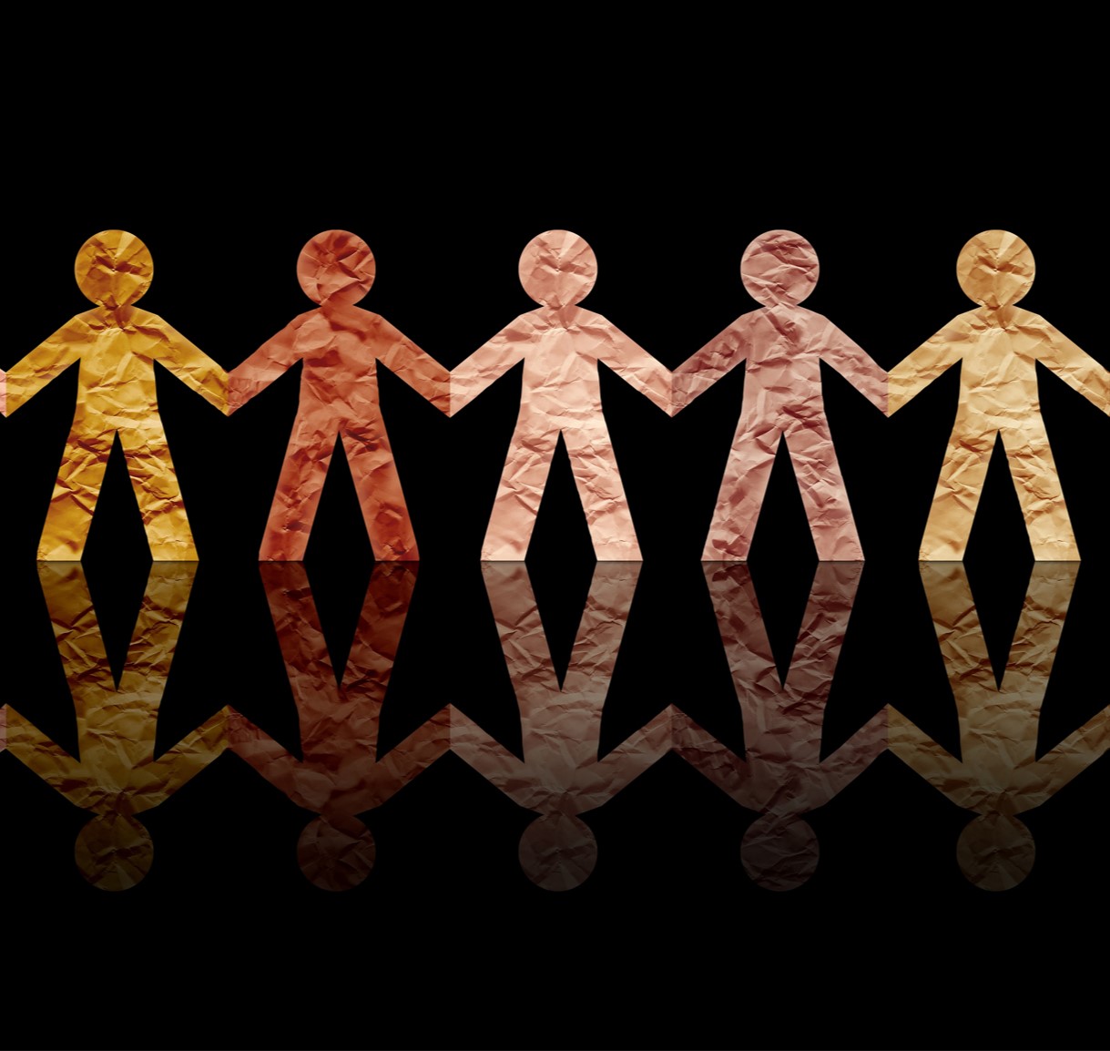 A chain of paper dolls of various skins tones holding hands,