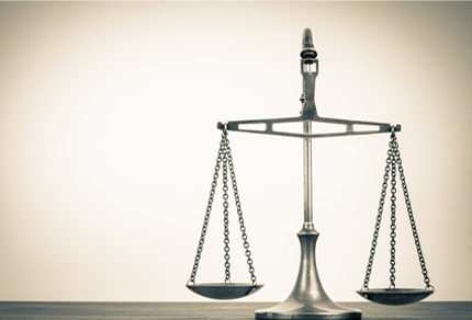 Scales of Justice with a simple beige background.