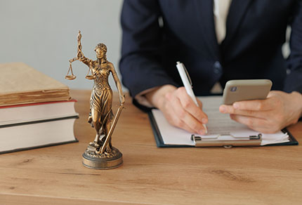 A lawyer making notes while looking at their phone.