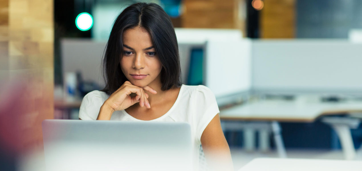 A business woman using a laptop in an office.